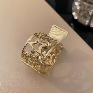Close-up of golden metal hair claw clip with elegant hollow star design details.