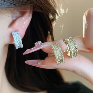 Gros plan détaillé de boucles d'oreilles à clip en zircon plaqué or 18k sur un modèle