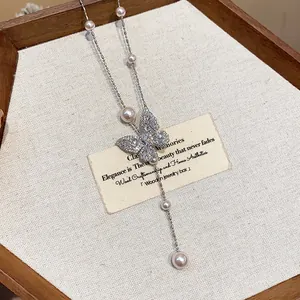 Close-up of elegant butterfly necklace with shimmering zircons and dainty pearls detail