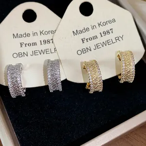 Gros plan de boucles d'oreilles clips en zircon plaqué or 18 carats avec finition texturée