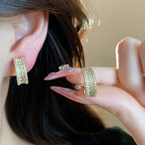 Détail macro de boucles d'oreilles clips en or 18 carats avec zircons sur l'oreille