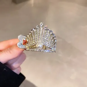 Close-up of crown hair claw clip with sparkly rhinestones and a central pearl detail.