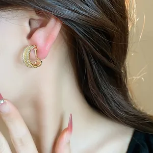 Gros plan d'un clip d'oreille en zircon plaqué or 18 carats sur une oreille féminine