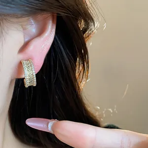 Détail rapproché des boucles d'oreilles clip en or 18 carats avec zircons pavés