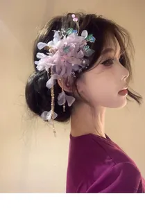 Detailed view of lavender mesh flower hair clip with delicate petal and tassel accents