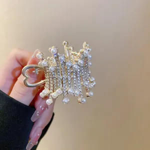 Close-up of crown hair claw clip with pearls and rhinestones decoration