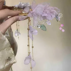 Detailed close-up of a purple mesh flower hair clip with elegant golden tassels