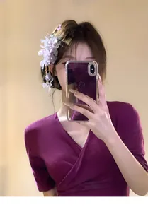 Close-up of a model wearing a sweet fabric flower hair clip with hanging tassels.