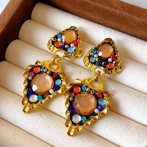 Close-up of vintage royal style geometric drop earrings with colorful rhinestones