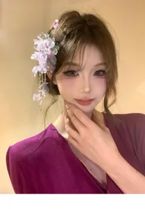 Close-up of a sweet purple mesh flower hair clip with tassels worn by an Asian model