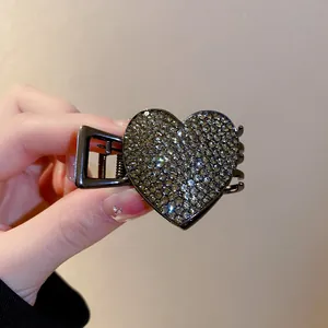 Close-up macro view of a sparkling heart-shaped rhinestone hair claw clip for women.
