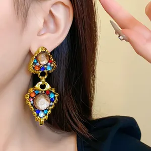 Detailed macro view of vintage palace style gold earrings with colorful rhinestones and pearls
