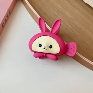 Close-up detail of a cute pink cartoon rabbit hair claw clip with matte finish texture.