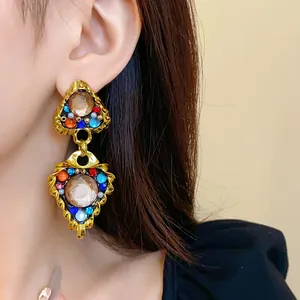 Close-up of vintage court style geometric earrings with colorful rhinestones on a model