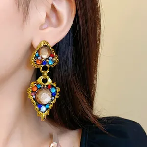 Vintage palace style drop earrings with colorful stones shown in a detailed close-up view