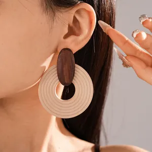 Detailed close-up shot of bohemian spiral wooden hoop earrings worn by an elegant model.