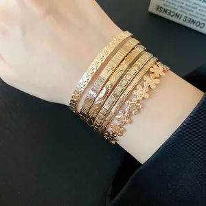 Elegant set of gold-toned open bangles featuring textured star and flower patterns for women