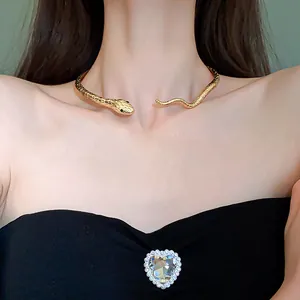 Elegant gold snake-shaped choker necklace with green gem eyes for a cool girl look