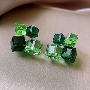 Macro view of forest style green cubic resin stud earrings with a translucent finish