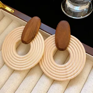 Macro view of bohemian spiral wooden hoop earrings presented in a velvet jewelry box