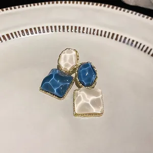Elegantes pendientes de botón cuadrados con textura ondulada en azul y crema suave