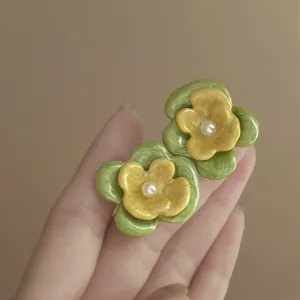 Detailed view of forest style resin flower earrings featuring pearl center and vibrant petals