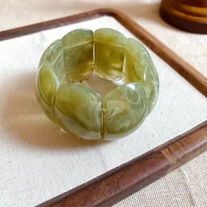 Close-up detail of green marbled acrylic bracelet with bold rectangular segments