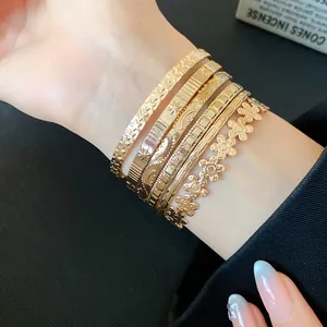 Set of 6 gold-tone textured metal bangles featuring stars, moons, and flower patterns.