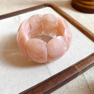 Detail of peach marbled acrylic bracelet with smooth square-shaped resin segments