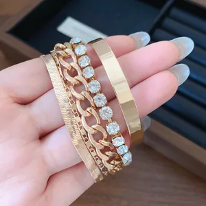 Close-up of four-piece gold-tone stackable bracelet set with rhinestones