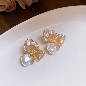 Close-up of French retro three-petal flower stud earrings with pearlescent finish