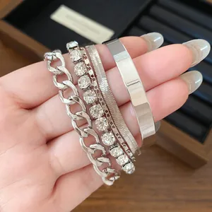 Detailed view of 4-piece silver-toned bracelet set featuring link and rhinestone styles.