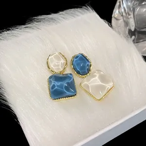 Primer plano de pendientes cuadrados irregulares con textura de ondas de agua azul y blanca.