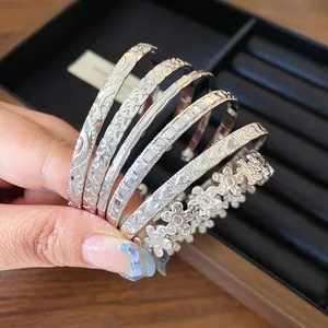 Detailed view of silver-toned open bangles with star and flower embossed textures.