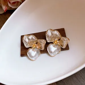 Detail of French vintage three-petal flower stud earrings with pearlescent finish