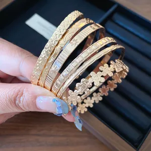 Detailed close-up of gold-colored textured bangles with flower and star patterns