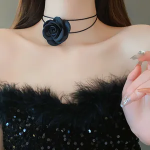Detailed close-up of an elegant black fabric rose choker with double leather cord
