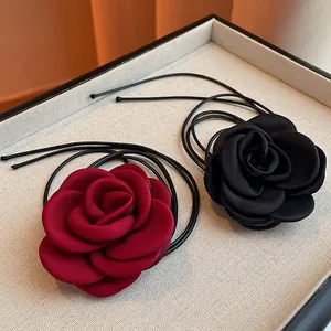Detailed close-up view of elegant burgundy and black fabric rose chokers with black cord ties.