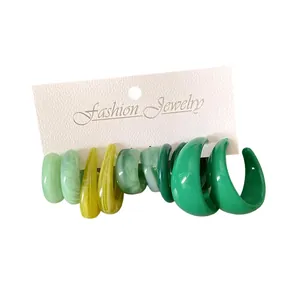 Set di orecchini a perno geometrici in acrilico a forma di C in sfumature di verde e giallo.