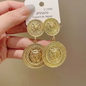 Vintage style golden lion head round dangle earrings with textured rope border designs.