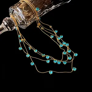 Détail macro du collier multi-rangs en or avec pierres de zircon rondes bleu turquoise