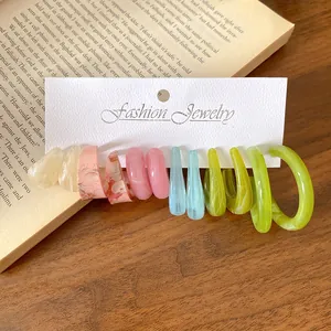 Collezione di orecchini a cerchio a C in acrilico colorato su una scheda per gioielli
