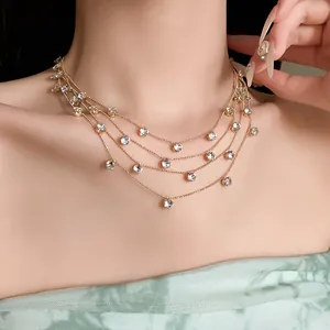 Vue détaillée d'un collier multicouche doré avec zircons ronds sur cou de modèle