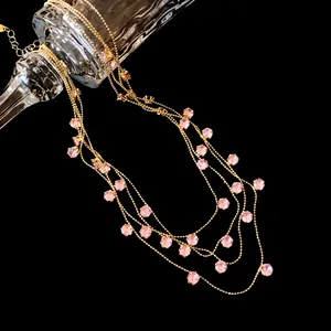 Détail d'un collier multicouche en or avec des zircons roses arrondis au style vintage chic