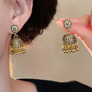 Orecchini Jhumka bohémien vintage in oro con motivo floreale intagliato e piccole nappe