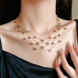 Détail d'un collier multicouche doré avec des pierres en zircone violette sur mannequin