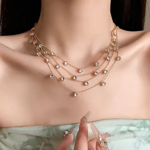 Gros plan détaillé d'un collier doré multi-rangs avec des oxydes de zirconium ronds.