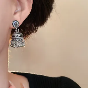 Dettaglio di orecchini vintage bohémien in argento con nappe sull'orecchio della modella