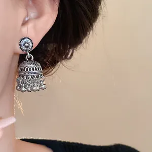 Primo piano di orecchini vintage in argento stile boho con incisioni e nappe