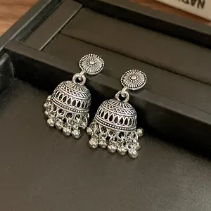 Primo piano di orecchini jhumka in argento vintage con incisioni e pendenti a pallina